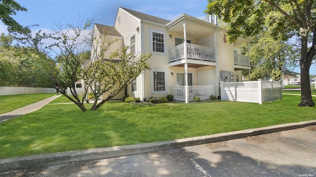 view of front of property with a balcony and a front yard