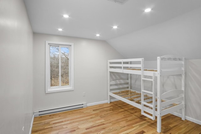 unfurnished bedroom featuring hardwood / wood-style flooring, lofted ceiling, and baseboard heating