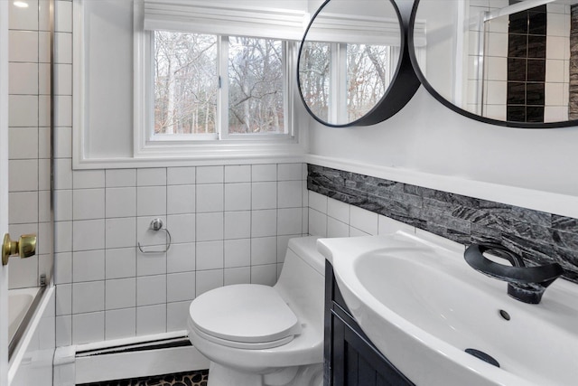 bathroom with vanity, toilet, a baseboard radiator, and tile walls