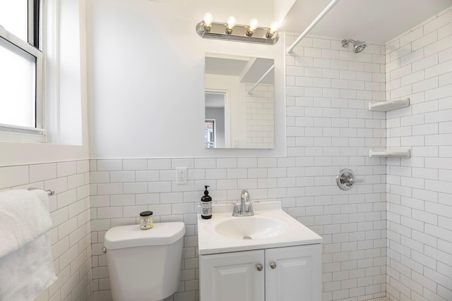 bathroom with vanity, toilet, and a tile shower