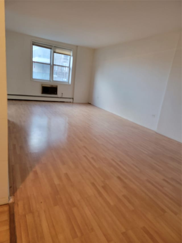 unfurnished room featuring light hardwood / wood-style floors and baseboard heating