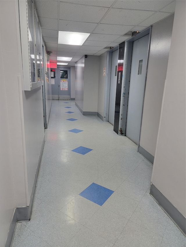 hallway with a paneled ceiling