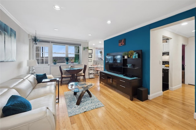 living room with light wood-type flooring and ornamental molding