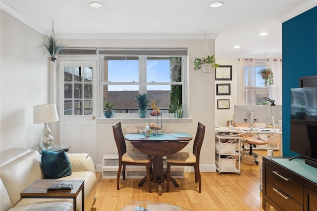 dining room with light wood-type flooring and ornamental molding