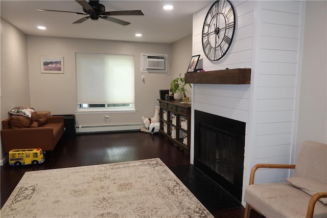 living room with a wall mounted air conditioner, dark hardwood / wood-style floors, ceiling fan, a fireplace, and a baseboard radiator