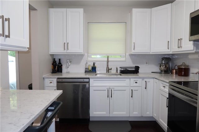 kitchen with light stone countertops, sink, white cabinetry, and stainless steel appliances