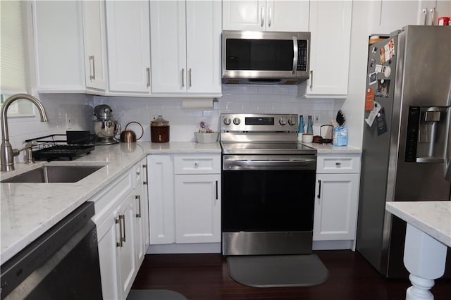 kitchen featuring white cabinets, decorative backsplash, stainless steel appliances, and sink