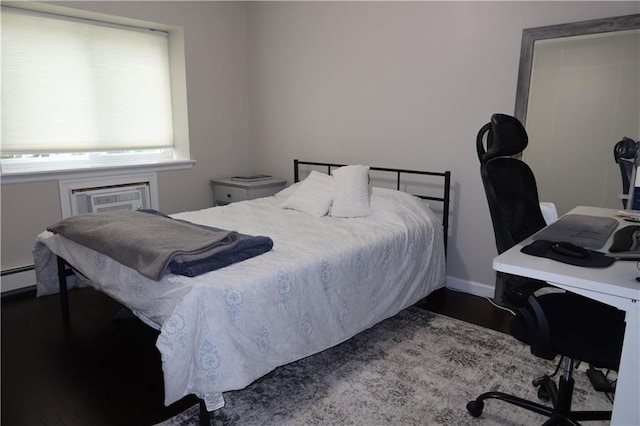 bedroom with a wall mounted air conditioner and baseboard heating