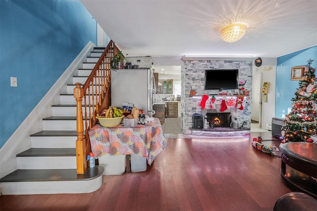 living room with a fireplace, hardwood / wood-style floors, and a notable chandelier