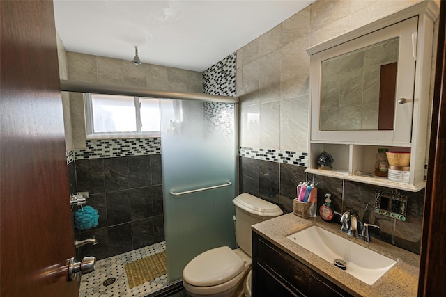 bathroom with vanity, decorative backsplash, toilet, tiled shower, and tile walls