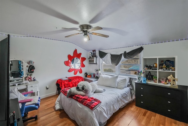 bedroom with ceiling fan, lofted ceiling, and hardwood / wood-style flooring