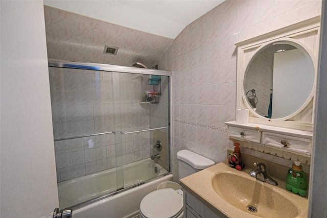 full bathroom featuring vanity, toilet, tile walls, and enclosed tub / shower combo