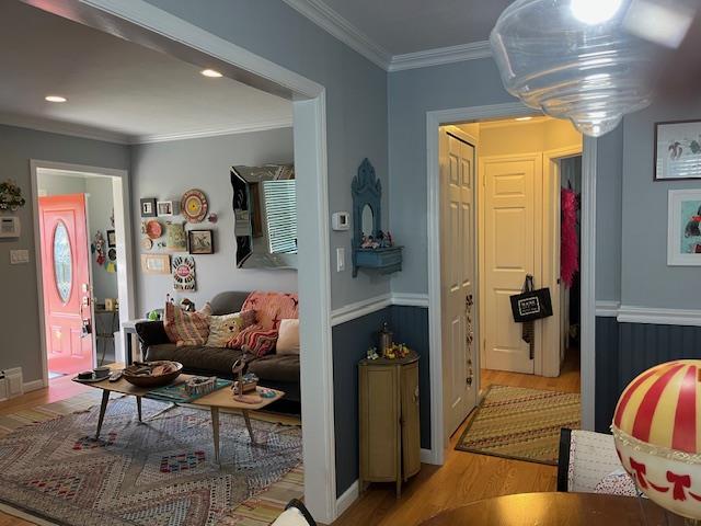 living room featuring light wood-type flooring and ornamental molding