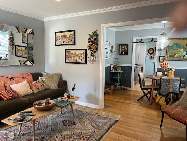 living room with light hardwood / wood-style floors and ornamental molding