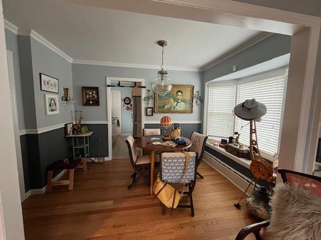 dining area with hardwood / wood-style floors, a barn door, and crown molding