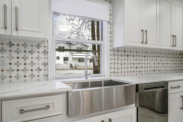 kitchen featuring white cabinets, sink, stainless steel dishwasher, tasteful backsplash, and light stone counters