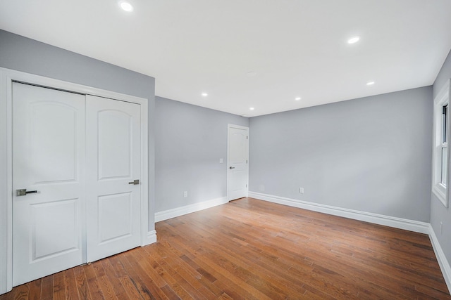 unfurnished bedroom with wood-type flooring and a closet