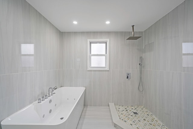 bathroom with separate shower and tub and tile walls