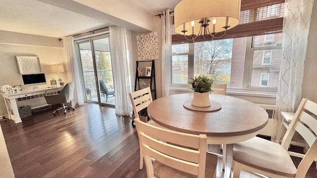 dining space with dark hardwood / wood-style flooring and a notable chandelier