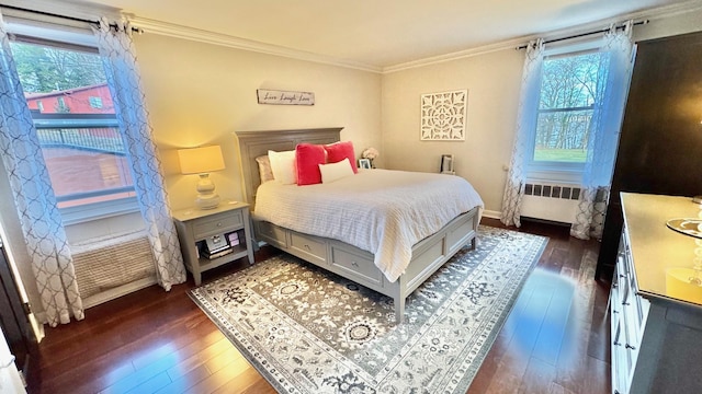 bedroom featuring dark hardwood / wood-style flooring, ornamental molding, and radiator