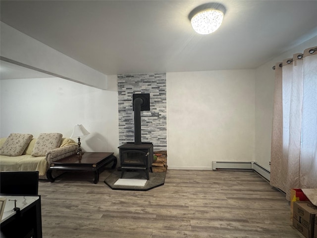 living room featuring hardwood / wood-style flooring, a wood stove, and baseboard heating