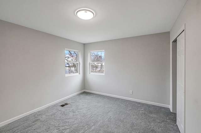 unfurnished bedroom featuring dark colored carpet and a closet