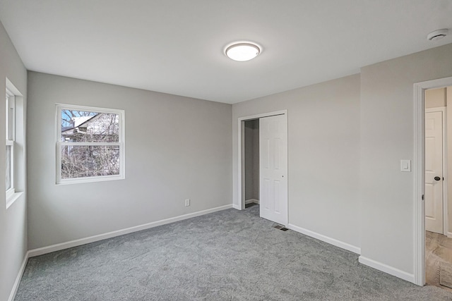 unfurnished bedroom featuring light colored carpet and a closet