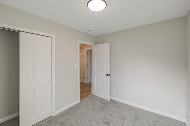 unfurnished bedroom featuring light colored carpet and a closet