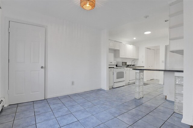 kitchen featuring light tile patterned flooring, white cabinetry, sink, kitchen peninsula, and white appliances