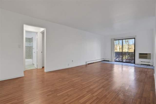unfurnished living room with a baseboard heating unit, light hardwood / wood-style flooring, and a wall mounted AC