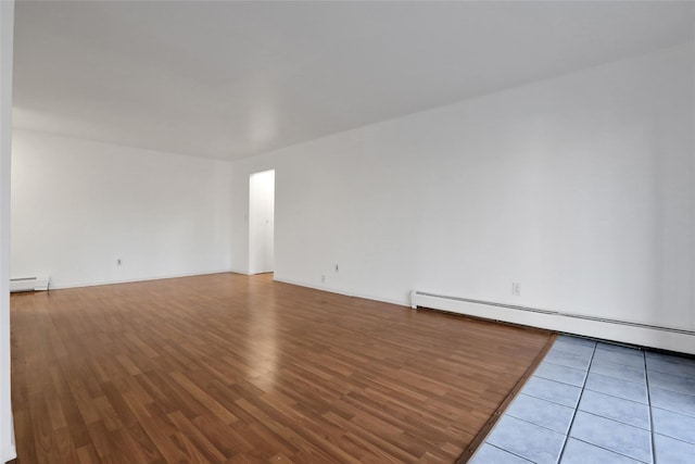 spare room with a baseboard heating unit and tile patterned floors