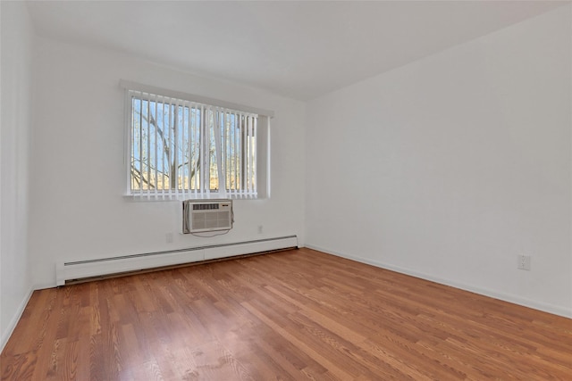 unfurnished room with a wall mounted air conditioner, light hardwood / wood-style flooring, and baseboard heating