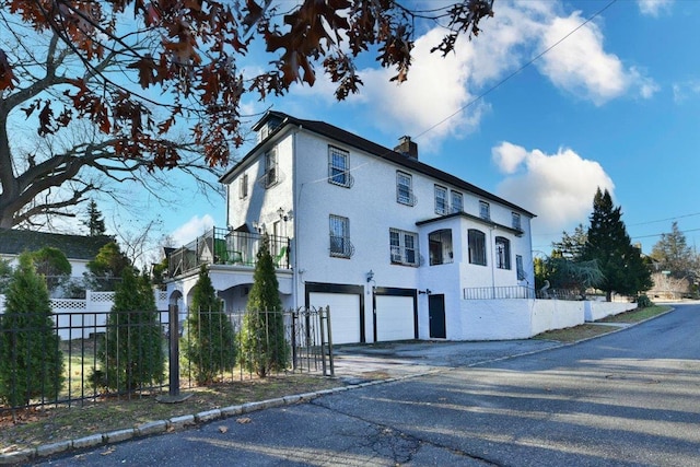 view of property exterior featuring a balcony and a garage