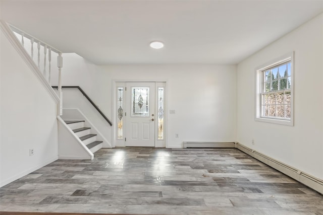 foyer entrance featuring baseboard heating and light hardwood / wood-style flooring