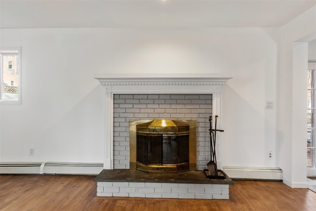 room details featuring hardwood / wood-style floors, a fireplace, and a baseboard radiator