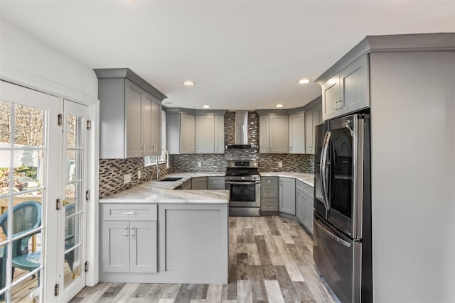 kitchen with stainless steel appliances, tasteful backsplash, wall chimney exhaust hood, and gray cabinetry