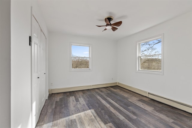 unfurnished bedroom featuring ceiling fan, a closet, dark hardwood / wood-style flooring, and a baseboard heating unit