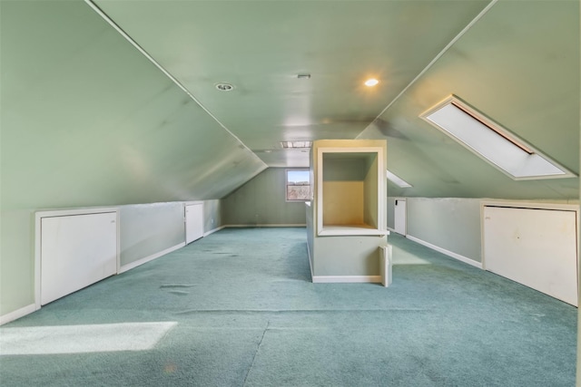 additional living space featuring light carpet and vaulted ceiling with skylight