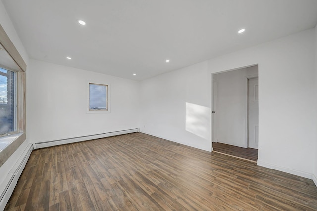 unfurnished room with baseboard heating and dark wood-type flooring