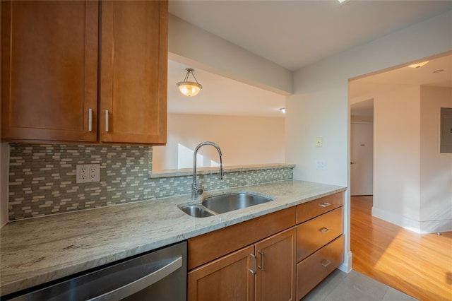 kitchen featuring dishwasher, electric panel, sink, light stone countertops, and tasteful backsplash