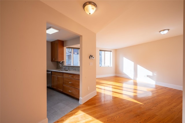 kitchen featuring dishwasher, light hardwood / wood-style floors, sink, and tasteful backsplash