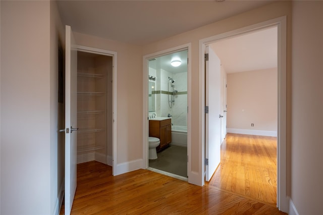 hall with hardwood / wood-style floors and sink