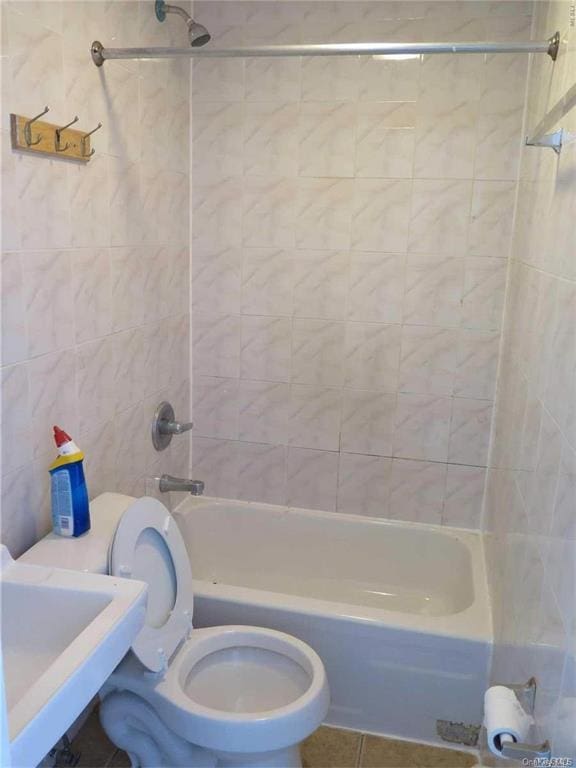 full bathroom featuring sink, tile patterned flooring, tiled shower / bath combo, and toilet