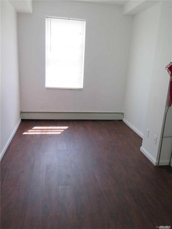 spare room featuring dark hardwood / wood-style floors and baseboard heating