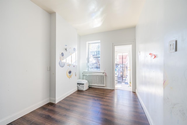 foyer entrance with radiator heating unit and dark hardwood / wood-style floors