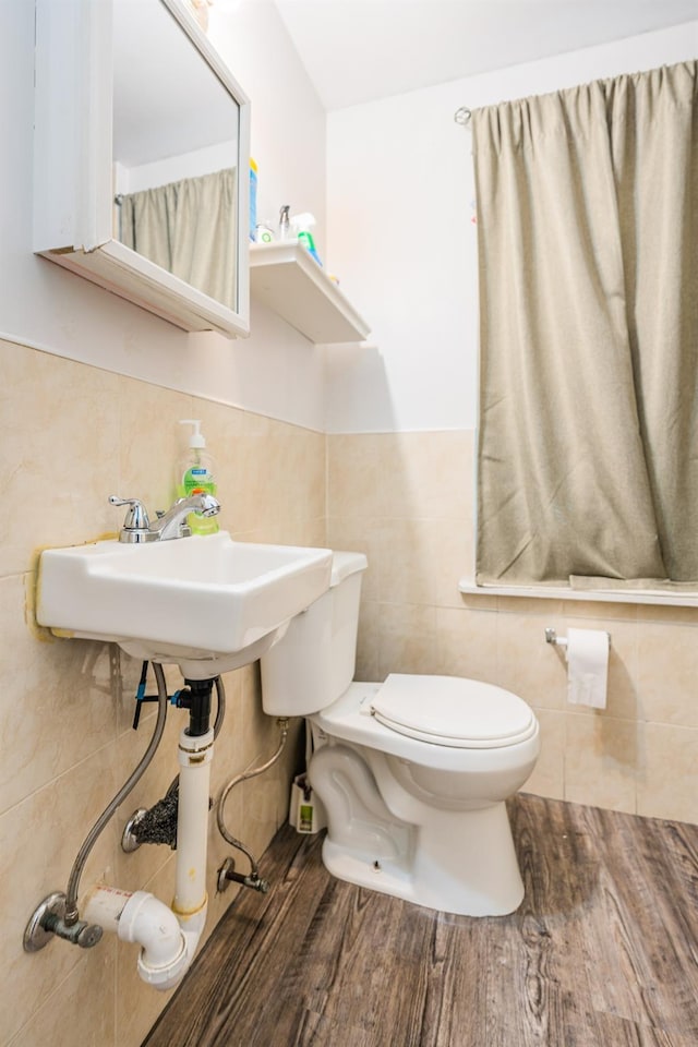 bathroom with wood-type flooring, toilet, tile walls, and sink