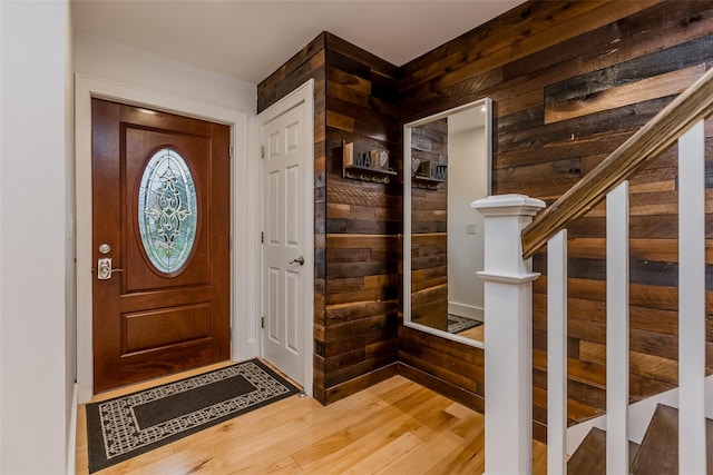 foyer with wood-type flooring and wood walls