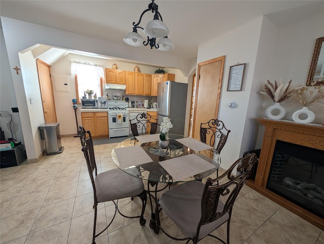 tiled dining area featuring a chandelier