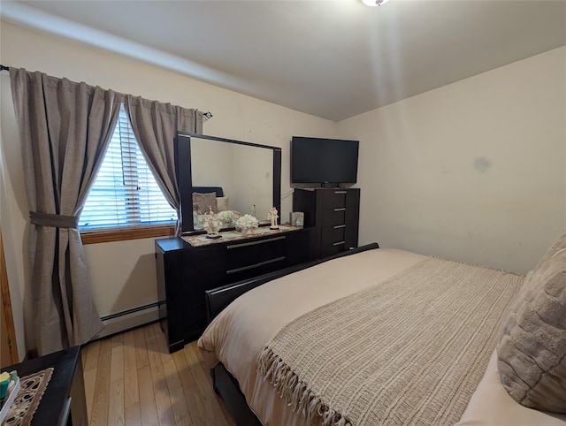 bedroom featuring baseboard heating and light hardwood / wood-style floors