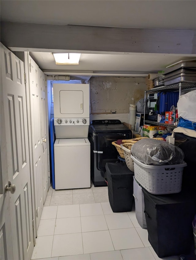 laundry area with stacked washer / dryer and light tile patterned floors